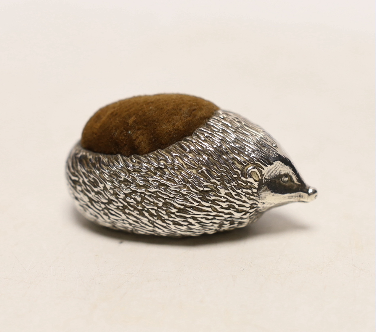 A modern novelty silver pin cushion modelled as a hedgehog, Ammonite Ltd, Birmingham, 1982, length 62mm.